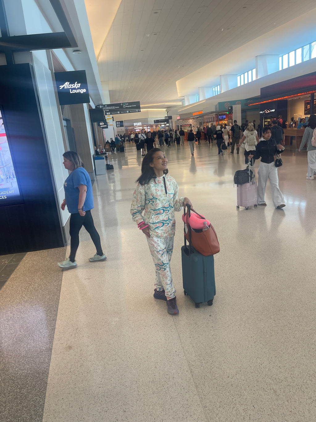 Woman wearing Floral Roo hoodie and joggers at airport