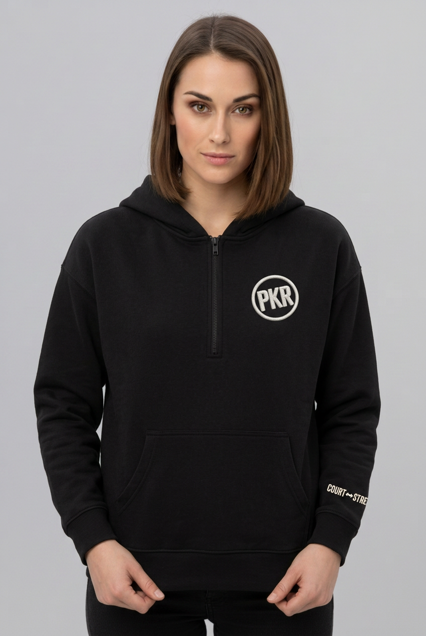 Woman wearing Pangkaroo Club’s black half-zip hoodie with off-white PKR chest detail and COURT ↔ STREET sleeve print.